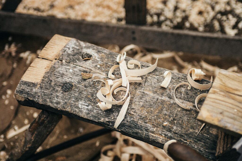 Rustic workbench covered in wood shavings, showcasing detailed craftsmanship.